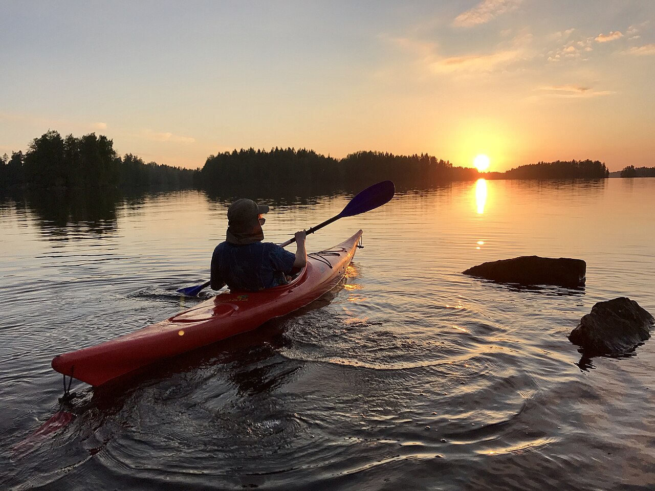 Kajakki tyynellä järvellä metsän ympäröimänä
